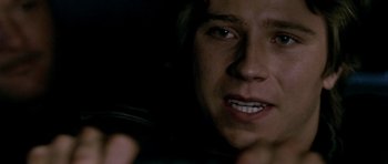 Movie still from “Friday Night Lights” (2004), directed by Peter Berg – A person's face in the dark; Close Up shot, Over the shoulder angle