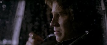 Movie still from “Friday Night Lights” (2004), directed by Peter Berg – A man is smoking a cigarette in the dark; Close Up shot, Over the shoulder angle