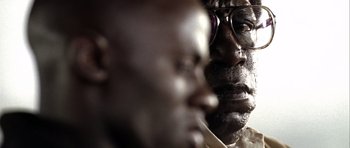 Movie still from “Friday Night Lights” (2004), directed by Peter Berg – A man's face in a dark room; Extreme Close Up shot, Over the shoulder angle