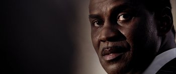 Movie still from “Friday Night Lights” (2004), directed by Peter Berg – A man's face in a dark room; Extreme Close Up shot, Low angle