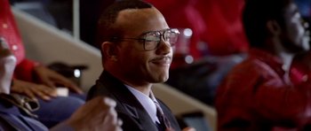 Movie still from “Friday Night Lights” (2004), directed by Peter Berg – A person wearing glasses and a suit; Close Up shot, Low angle