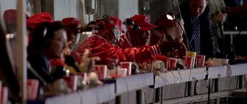 Movie still from “Friday Night Lights” (2004), directed by Peter Berg – A group of men sitting at a table with cups; Medium shot, High angle