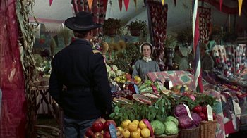Movie still from “Friendly Persuasion” (1956), directed by William Wyler – A man and a woman at a fruit and vegetable stand; Medium shot, Over the shoulder angle