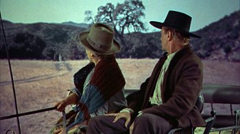Movie still from “Friendly Persuasion” (1956), directed by William Wyler – An older man and woman riding a horse and buggy; Wide shot, High angle
