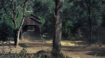 Movie still from “Friendly Persuasion” (1956), directed by William Wyler – An old covered bridge in the middle of a forest; Extreme Wide shot, High angle