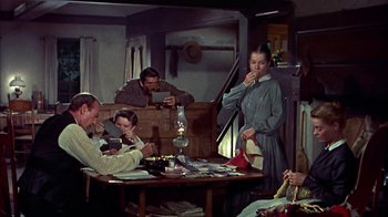 Movie still from “Friendly Persuasion” (1956), directed by William Wyler – A group of people sitting around a table; Wide shot, High angle