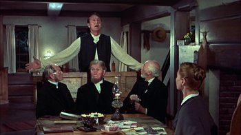 Movie still from “Friendly Persuasion” (1956), directed by William Wyler – A group of people sitting around a table; Medium shot, Low angle