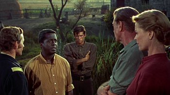 Movie still from “Friendly Persuasion” (1956), directed by William Wyler – A group of men standing next to each other in a field; Medium shot, Over the shoulder angle