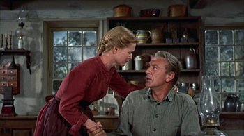 Movie still from “Friendly Persuasion” (1956), directed by William Wyler – An older man and a young woman in a kitchen; Medium shot, Low angle