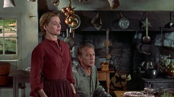 Movie still from “Friendly Persuasion” (1956), directed by William Wyler – A man and a woman standing in front of a fireplace; Medium shot, Low angle