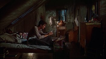 Movie still from “Friendly Persuasion” (1956), directed by William Wyler – A man sitting on the floor in a room; Wide shot, High angle