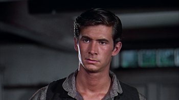 Movie still from “Friendly Persuasion” (1956), directed by William Wyler – A young man with short black hair wearing a black vest; Close Up shot, Low angle