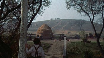 Movie still from “Friendly Persuasion” (1956), directed by William Wyler – A person standing next to a tree in a field; Extreme Wide shot, High angle