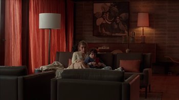 Movie still from “Friends with Money” (2006), directed by Nicole Holofcener – A woman and a child are sitting on a couch; Wide shot, Low angle