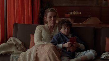 Movie still from “Friends with Money” (2006), directed by Nicole Holofcener – A woman sitting next to a child on a couch; Medium shot, Over the shoulder angle