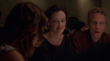 Movie still from “Friends with Money” (2006), directed by Nicole Holofcener – A woman sitting at a table with other people in the background; Close Up shot, Over the shoulder angle