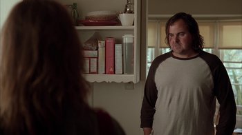Movie still from “Friends with Money” (2006), directed by Nicole Holofcener – A man standing in front of a woman in front of a shelf; Medium shot, Over the shoulder angle