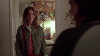 Movie still from “Friends with Money” (2006), directed by Nicole Holofcener – A woman standing in front of a man in a room with pictures on the wall; Medium shot, Over the shoulder angle