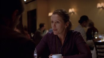 Movie still from “Friends with Money” (2006), directed by Nicole Holofcener – A woman sitting at a table with a cup of coffee; Close Up shot, Over the shoulder angle