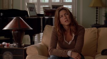 Movie still from “Friends with Money” (2006), directed by Nicole Holofcener – A woman sitting in a chair with her arms crossed; Medium shot, High angle