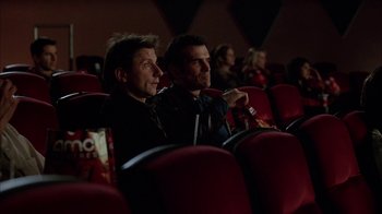 Movie still from “Friends with Money” (2006), directed by Nicole Holofcener – A couple of men are sitting in a movie theater; Medium shot, Low angle