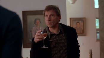 Movie still from “Friends with Money” (2006), directed by Nicole Holofcener – A man holding a glass of wine in his hand; Close Up shot, Low angle