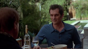 Movie still from “Friends with Money” (2006), directed by Nicole Holofcener – A man sitting at a table with a glass of wine; Medium shot, Over the shoulder angle