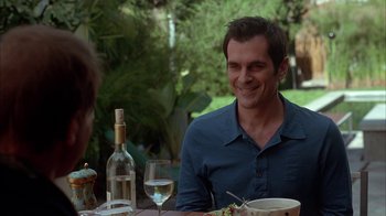 Movie still from “Friends with Money” (2006), directed by Nicole Holofcener – A man sitting at a table with a glass of white wine; Medium shot, Over the shoulder angle
