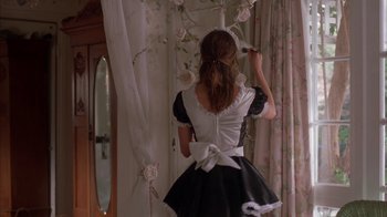 Movie still from “Friends with Money” (2006), directed by Nicole Holofcener – A woman dressed as a french maid in a room; Medium shot, Over the shoulder angle
