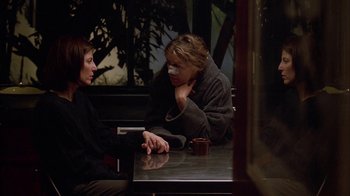 Movie still from “Friends with Money” (2006), directed by Nicole Holofcener – Two women are sitting at a table and talking to each other; Medium shot, Over the shoulder angle