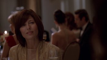 Movie still from “Friends with Money” (2006), directed by Nicole Holofcener – A person sitting at a table in a room; Close Up shot, Over the shoulder angle