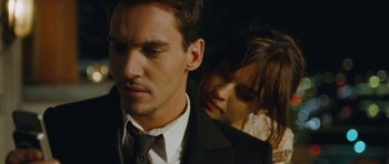 Movie still from “From Paris with Love” (2010), directed by Pierre Morel – A man and a woman standing next to each other; Close Up shot, Over the shoulder angle
