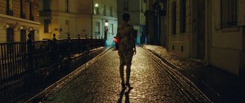 Movie still from “From Paris with Love” (2010), directed by Pierre Morel – A person walking down a street at night; Wide shot, High angle