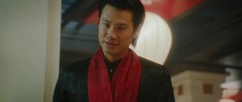 Movie still from “From Paris with Love” (2010), directed by Pierre Morel – A person wearing a suit and a red scarf; Close Up shot, Low angle