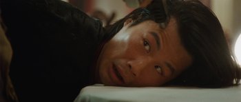 Movie still from “From Paris with Love” (2010), directed by Pierre Morel – A person laying on a bed; Close Up shot, Overhead angle