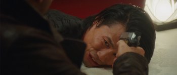 Movie still from “From Paris with Love” (2010), directed by Pierre Morel – A person laying on a bed; Close Up shot, High angle