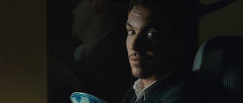 Movie still from “From Paris with Love” (2010), directed by Pierre Morel – A person wearing a suit and tie; Close Up shot, Low angle