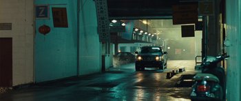 Movie still from “From Paris with Love” (2010), directed by Pierre Morel – A car driving down a street at night; Wide shot, Low angle