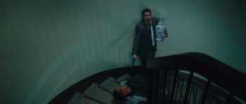 Movie still from “From Paris with Love” (2010), directed by Pierre Morel – A man in a suit and tie holding a knife near a man in a suit and tie; Wide shot, High angle