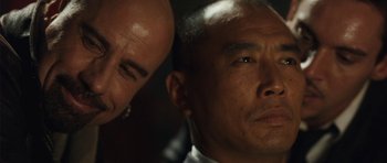 Movie still from “From Paris with Love” (2010), directed by Pierre Morel – A man with a bald head and a man with a bald head; Close Up shot, Over the shoulder angle