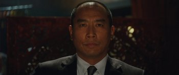 Movie still from “From Paris with Love” (2010), directed by Pierre Morel – A person wearing a suit and tie; Close Up shot, Low angle