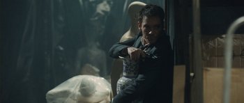 Movie still from “From Paris with Love” (2010), directed by Pierre Morel – A man holding a vase in his hand; Medium shot, Over the shoulder angle