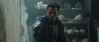 Movie still from “From Paris with Love” (2010), directed by Pierre Morel – A man holding a gun while wearing a black jacket; Medium shot, Low angle