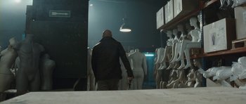 Movie still from “From Paris with Love” (2010), directed by Pierre Morel – A man walking through a room full of mannequins; Wide shot, Over the shoulder angle