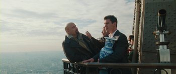 Movie still from “From Paris with Love” (2010), directed by Pierre Morel – Two men sitting on a balcony drinking wine; Medium shot, Low angle