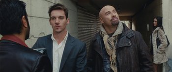 Movie still from “From Paris with Love” (2010), directed by Pierre Morel – A couple of men standing next to each other; Close Up shot, Low angle