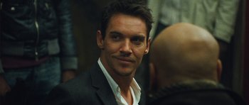 Movie still from “From Paris with Love” (2010), directed by Pierre Morel – A person wearing a suit and tie; Close Up shot, Over the shoulder angle