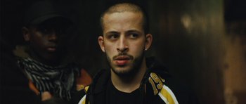 Movie still from “From Paris with Love” (2010), directed by Pierre Morel – A person wearing a jacket; Close Up shot, Low angle