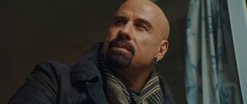 Movie still from “From Paris with Love” (2010), directed by Pierre Morel – A bald man with a beard and a scarf around his neck; Close Up shot, Low angle
