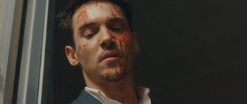 Movie still from “From Paris with Love” (2010), directed by Pierre Morel – A person with blood all over his face; Close Up shot, Low angle